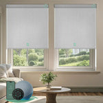 Motorised blockout roller blinds in fabric greyish white fabric, installed in a living room, offering soft daylight privacy with smart app and remote control.