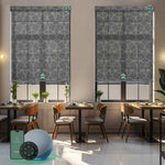 Motorised sunscreen roller blinds with 3% openness in geometric black fabric, filtering daylight while maintaining outdoor views and privacy